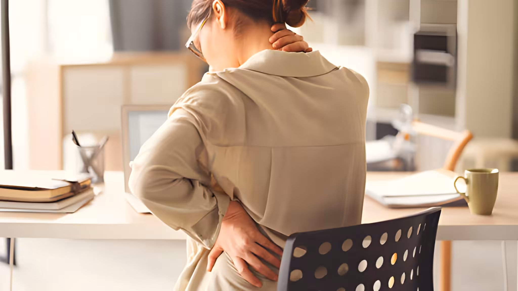 conditions treated back and neck pain woman sitting at table